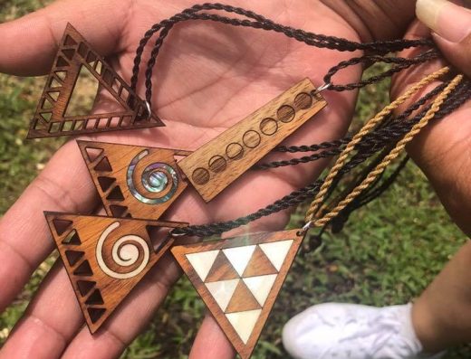 Handmade Hawaiian jewelry crafted from Koa and other fine woods by Michael, featuring intricate laser-cut designs.