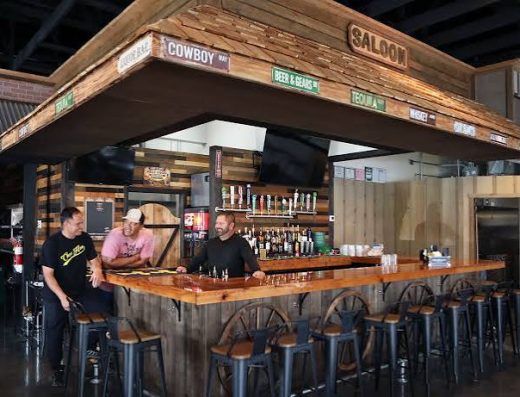 Rustic saloon bar inside Marzo's Country Sports Bar & Grill in Pāhoa, Hawaiʻi, featuring a handcrafted wood bar, full beverage selection, country western décor, and a welcoming atmosphere.